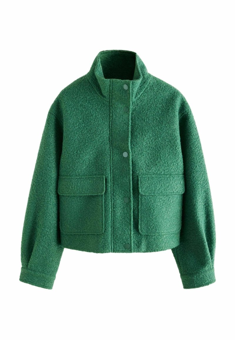 Veste courte verte en tissu texturé. Dotée d'un col montant, de boutons à l'avant et de deux grandes poches avant.