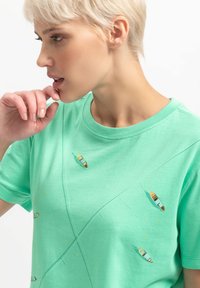 Mintgroene katoenen t-shirt met geprinte bootontwerpen, ronde hals, korte mouwen en een relaxte pasvorm met stikdetails.
