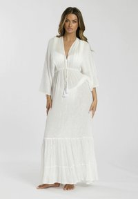 Vestido maxi blanco con cintura ajustable, que presenta un escote en V profundo, mangas de campana y un dobladillo con volantes. Fabricado en una tela ligera y texturada.