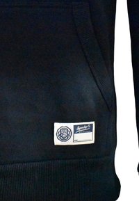 Felpa nera con polsini e orlo a costine. Presenta un'etichetta bianca con testo blu ed emblema, che indica "Superdry Co" e "OSAKA 6."