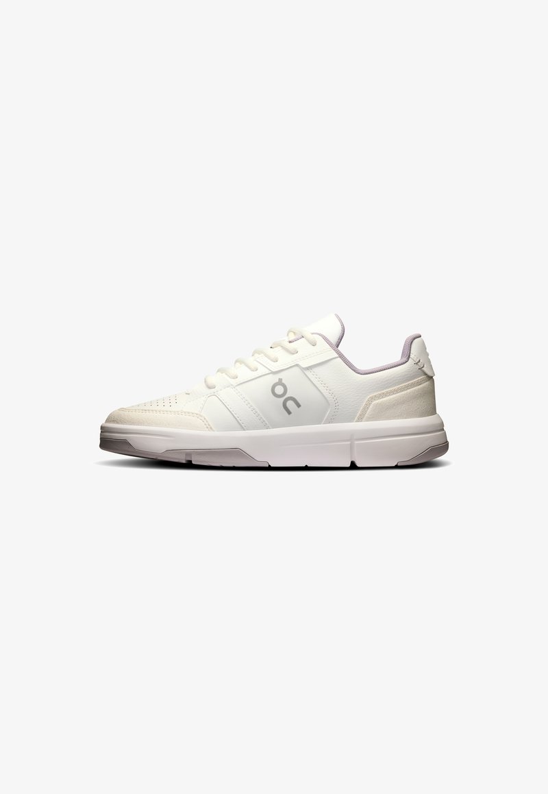 White athletic sneakers featuring a textured upper, lace closure, and subtle gray accents. The sole is thick and cushioned for support.