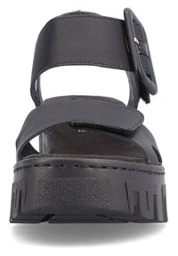 Sandal en cuir noir avec une boucle, bout ouvert, et une semelle épaisse texturée avec des découpes. Design plat et style minimaliste.