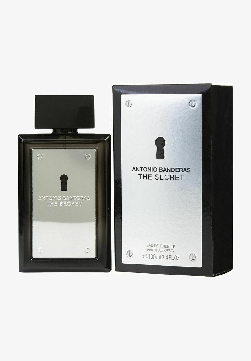 Eau de Toilette mustassa suorakulmaisessa lasipullossa, jossa on hopeinen metallilaatta, jossa on avaimenreikäkuvio. Rikkinäinen pakkaus on musta hopeisilla yksityiskohdilla.