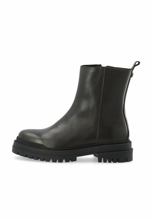 Bottine noire en cuir avec semelle crantée épaisse et fermeture éclair latérale, vue de profil sur fond blanc.