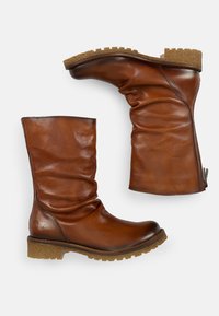 Botas de cuero marrón hasta el tobillo con un diseño arrugado, parte superior texturizada y suela robusta. Cuenta con una cremallera lateral para facilitar el uso.
