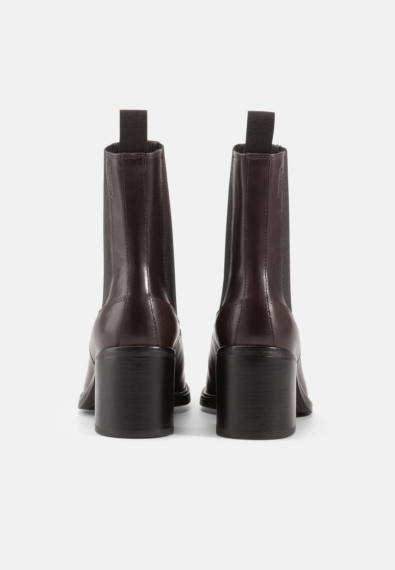 Stivali in pelle marrone sopra la caviglia con tacco quadrato, pannelli laterali elasticizzati e una finitura elegante. Il design è moderno con un profilo minimale.