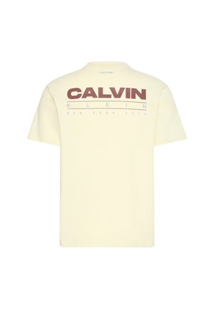T-shirt crème à manches courtes avec un grand texte "CALVIN KLEIN NEW YORK CITY" imprimé au dos en marron et bleu clair.