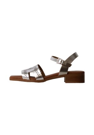 Sølv lavhælet sandal med perforeret frontrem, justerbar ankelrem med spænde og brun træsål.