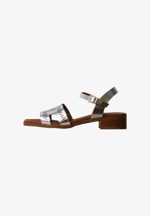 Sølv lavhælet sandal med perforeret frontrem, justerbar ankelrem med spænde og brun træsål.