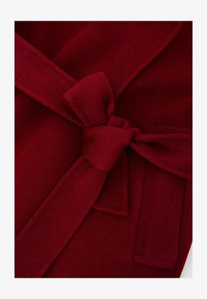 Punane villaseguse kanga hommikumantel, millel on nööriga vöö, pehme tekstuur ja krae. Sisaldab õmmeldud detaile ja küljetaskut.