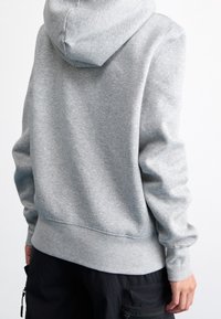 Grå huvtröja i mjuk bomullsblandning, med ribbade avslut på ärmar och sidor, som har en avslappnad passform och enkel design.