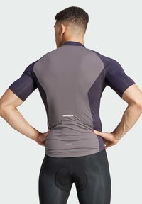 Fitted short-sleeve cycling jersey in gray and dark blue, featuring sleek, moisture-wicking fabric, and a back pocket with a reflective strip.