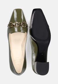 Mocassini in pelle verniciata verde con punta quadrata, accentati da una catena dorata e suola in gomma nera solida. Interno foderato in un materiale beige.