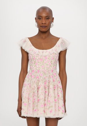 Bloem geborduurd jurk met een lichtroze basis, korte gerimpelde mouwen en een uitlopende rok met roze bloemen en groene stelen.