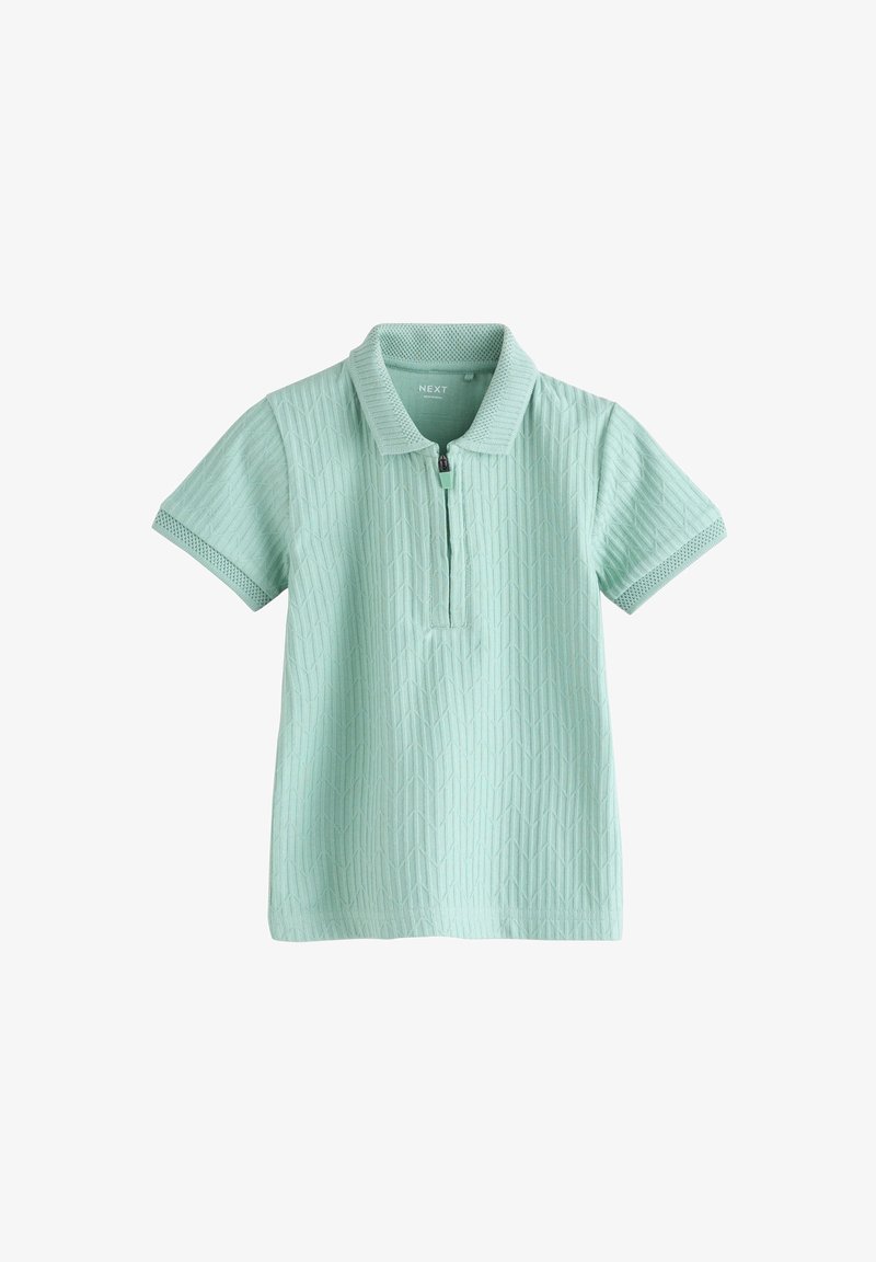Polo vert clair à manches courtes avec motif géométrique texturé et fermeture éclair à l'avant sous le col.