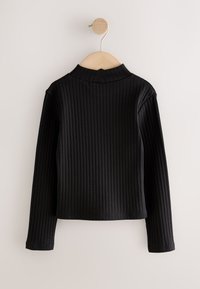 Top negro de manga larga con cuello alto y detalles acanalados, de diseño ajustado y bordes limpios, colgado en una percha de madera contra un fondo liso.