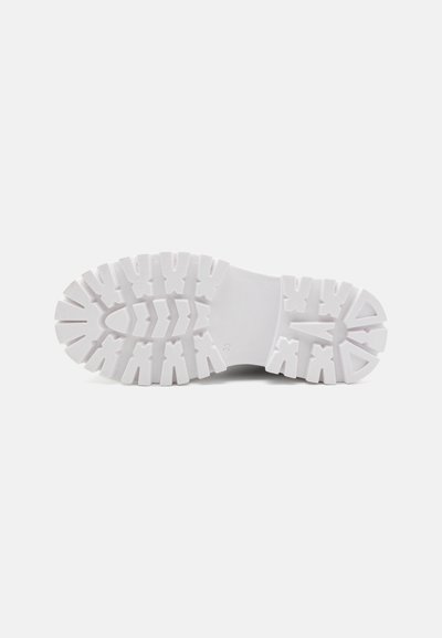 Suela de zapatilla de goma en blanco con patrones de textura y surcos para mayor tracción. Presenta una construcción robusta con una forma de punta redondeada.