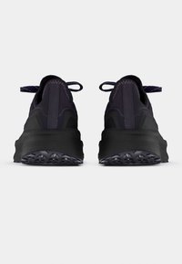 Paire de chaussures de sport noires et violet foncé vues de dos sur un fond clair uni.