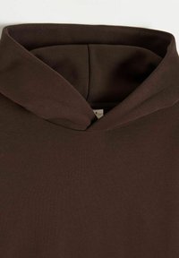 Zbliżenie ciemnobrązowej bluzy z kapturem, skupiające się na kapturze i szwach przy dekolcie.