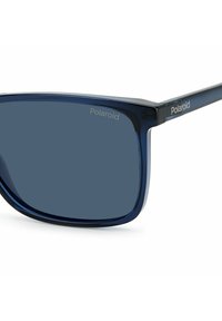 Occhiali da sole Polaroid con montatura in plastica blu scuro e lenti grigie scure. Presenta il logo sul lato e un design rettangolare elegante.