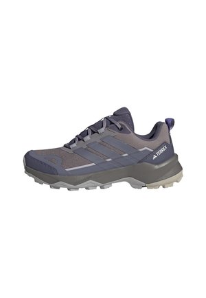 Scarpe da trail running in grigio scuro e viola, con parte superiore in mesh, suola in gomma e tre strisce orizzontali come elementi di design.