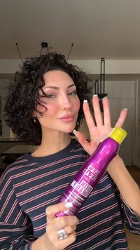 Lilla hårsprayboks med gult lokk, med en blank finish. Etiketten viser produktnavn og bruksdetaljer tydelig.