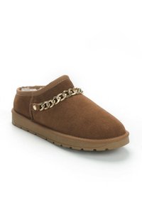 Scarpa slip-on in suede marrone con fodera morbida, un accento in catena dorata sulla parte anteriore e una suola in gomma testurizzata. Design con punta tondeggiante.