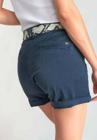 Donkerblauwe shorts met een opgerolde zoom, voorzien van een getextureerde, slangpatroon tailleband en achterzakken. Soepele katoenstof.