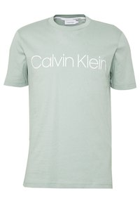 Camiseta de algodón verde claro con mangas cortas y cuello redondo. Presenta un logo blanco de "Calvin Klein" impreso en el pecho.