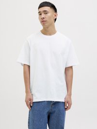 Weißes Baumwoll-T-Shirt mit kurzen Ärmeln, Rundhalsausschnitt und lockerer Passform. Kombiniert mit blauen Jeans im klassischen, geraden Schnitt.