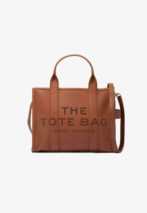 Geantă tote din piele maro, cu două mânere superioare și un bretele de umăr detașabil. Prezintă litere embossate "THE TOTE BAG" și "MARC JACOBS."