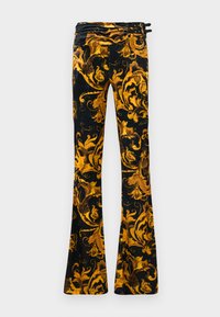 Pantalones acampanados de tela negra con elaborados patrones florales dorados. Presentan una cinturilla enrollada con varios botones negros y lazos.