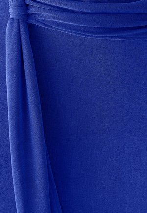 Kara zila auduma ar teksturētu, rievotu virsmu. Iespējota nošūta daļa, ko nostiprina izgriezta auduma detaļa.