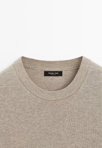 Beige sweater with a round neckline. Made of soft fabric with a fine knit texture. Features a label reading "Massimo Dutti" on the inside.