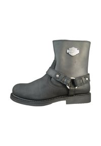 Bottine en cuir noir avec un bout arrondi, une boucle sur le côté, des accessoires en argent et une finition texturée. Logo Harley-Davidson à l'avant.