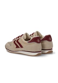 Zapatillas beige con acentos burdeos, material de ante y malla, tres líneas en los laterales, diseño de cordones y suela de goma texturizada.