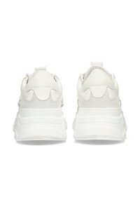 Baskets blanches avec une tige en cuir lisse et en daim, des détails texturés au niveau du talon, et une semelle blanche épaisse et rembourrée.