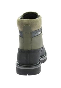 Bottes en cuir vert et noir avec une tige en daim, semelle robuste et talon renforcé. Détails de logo à l'arrière.
