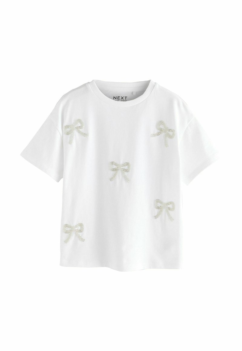 Hvid bomulds T-shirt med flere broderede lysegrå sløjfer. Korte ærmer, rund halsudskæring, afslappet pasform.