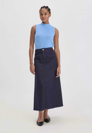 Top senza maniche di un blu chiaro abbinato a una lunga gonna in denim scuro con chiusura a bottoni frontale e linee pulite. Ballerine nere completano il look.