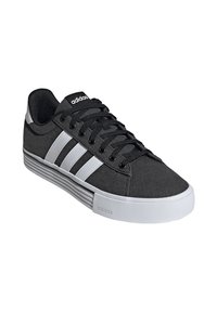 Czarne sneakersy Adidas z białymi paskami, czarnymi sznurowadłami i grubą białą podeszwą, z logo Adidas z boku i na języku.