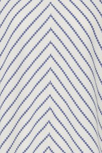 Weißer Stoff mit blauen, gepunkteten Chevron-Streifen, die ein sich wiederholendes V-Muster bilden und sich in der Bildmitte treffen.