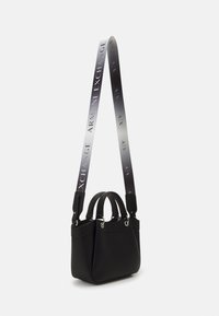 Czarna torebka o fakturowanej powierzchni, z dwoma górnymi uchwytami i metalowymi elementami. Posiada odpinany pasek z logo "ARMANI EXCHANGE".