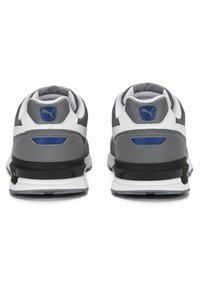 Scarpe da ginnastica grigie con accenti bianchi e neri. Presentano tacchi arrotondati, colli imbottiti, linguette in mesh e un logo prominente sul retro.