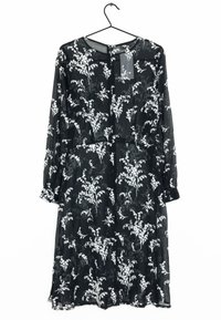 Robe noire à fleurs avec de longues manches, présentant des motifs de fleurs blanches, un col rond et un détail de lien à la taille. Tissu léger et transparent.