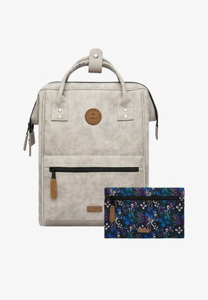 Rucksack mit einer strukturierten, hellgrauen Außenseite, ausgestattet mit einer vorderen Reißverschlusstasche und einem runden Logo-Patch. Enthält eine kleine Brieftasche mit floralem Muster.