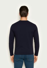 Granatowa koszulka z długim rękawem, wykonana z miękkiego materiału, z okrągłym dekoltem. Projekt charakteryzuje się gładką teksturą i dopasowanym krojem.