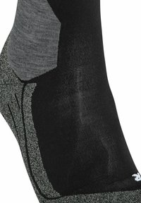 Calzino nero con dettagli grigi e un tallone rinforzato texturizzato. Materiale lavorato a maglia che presenta una combinazione di texture lisce e morbide.