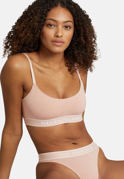 Lyserød bralette og matchende trusse med en blød ribbet tekstur. Har et hvidt logobånd med "POLO RALPH LAUREN" langs taljen.