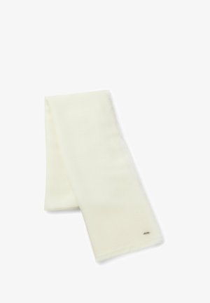 Écharpe douce de couleur crème pliée avec une petite étiquette métallique de marque près d’un bord sur fond blanc.